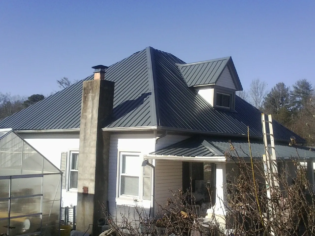 Dark blue standing seam metal roof on a white farmhouse with dormer — Slate & Tile Roof Repair by Roofing Brothers in Anatone